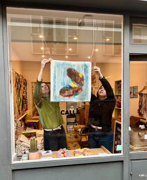 Installing artwork in the Calla Paris window