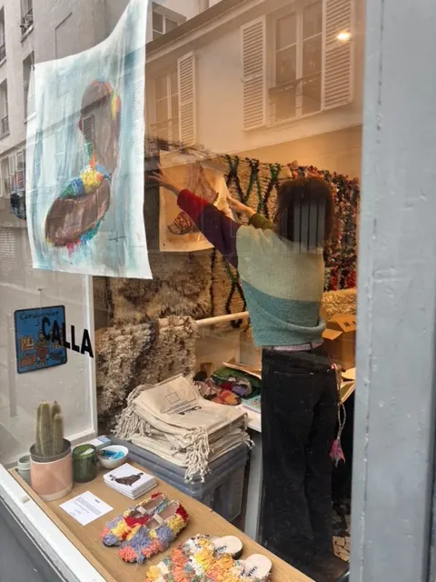 Final adjustments to the Calla Paris window display