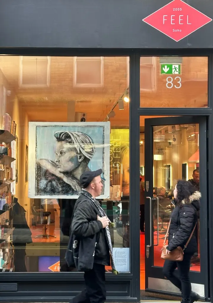 Passers-by stop at the Feel Soho window during the Allure exhibition